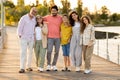 Smiling european multi-generation family hugs, enjoy vacation in city park, walk outdoor, full length Royalty Free Stock Photo