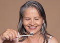 Smiling european senior grey-haired woman brushing her teeth with toothbrush, enjoy daily routines Royalty Free Stock Photo