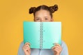 Smiling european teen school girl reading book, have fun at school, prepare to exam Royalty Free Stock Photo