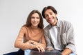 Smiling european young couple sit on floor in empty room look at computer and planning interior in new house Royalty Free Stock Photo