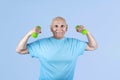 Excited pensioner practising bodybuilding exercising with dumbbells Royalty Free Stock Photo