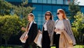 Smiling excited group of business women with shopping bags walking through the modern city taking details of three women Royalty Free Stock Photo