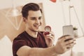 Smiling excited man making selfie with expensive wedding ring