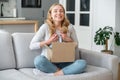 Smiling excited woman unpacking cardboard parcel order from online store