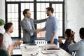 Smiling executive shaking successful employee hand, congratulating with promotion