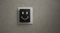 Smiling Face on Black and White Light Switch Cover Mounted on Textured Wall Royalty Free Stock Photo