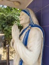 Smiling face with folded hands statue of mother Teresa with blue background