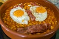 Funny english breakfast serving with smiling face of fried eggs and bacon on beans. Royalty Free Stock Photo
