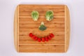 Smiling face made of Brussel sprouts broccoli floret cherry tomatoes Royalty Free Stock Photo