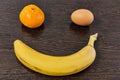 Smiling face made of tangerine banana and eggs on a light table
