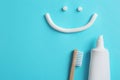 Smiling face made of toothpaste, tube, brush and space for text on color background