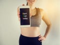 Smiling face of Young asian woman in sport bra hold smartphone Royalty Free Stock Photo