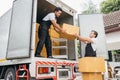 Workers in uniform exhibit teamwork unloading cardboard boxes from the moving Royalty Free Stock Photo