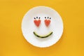 Smiling faces on a white plate. Heart shape from watermelon.