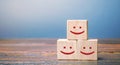 Smiling faces on wooden blocks. Feedback, critic`s assessment, service rating, ranking, customer reviews concept. Satisfaction an