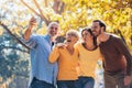 Family on an autumns day in park make selfie photo