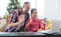 Smiling family on Christmas morning play music on piano.