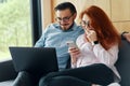 Smiling family couple laughing using computer and smartphone Royalty Free Stock Photo