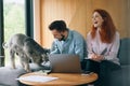 Smiling family couple laughing using computer and smartphone Royalty Free Stock Photo