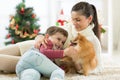 Smiling family and dog sitting by Christmas tree Royalty Free Stock Photo