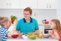 Smiling family eating breakfast in kitchen Royalty Free Stock Photo