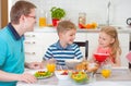 Smiling family eating breakfast in kitchen Royalty Free Stock Photo