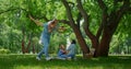 Smiling family have fun resting on nature. Parents play with childnen on picnic.