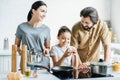 smiling family with little daughter cooking omelet Royalty Free Stock Photo