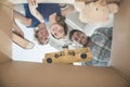 Smiling family looking into a cardboard box, view from directly under Royalty Free Stock Photo