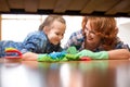 Smiling family mother and child girl clean room at home. Middle-aged woman and child girl wiped floor under bed Royalty Free Stock Photo