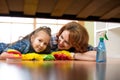 Smiling family mother and her daughter clean room at home. Middle-aged woman and child girl wiped floor under bed Royalty Free Stock Photo