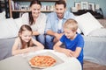 Smiling family with pizza on table Royalty Free Stock Photo
