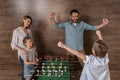 Smiling family playing foosball together Royalty Free Stock Photo