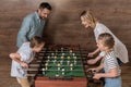 Smiling family playing foosball together