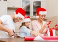 Smiling family in santa helper hats with gift box Royalty Free Stock Photo