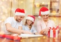 Smiling family in santa helper hats with gift box Royalty Free Stock Photo