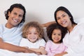 Smiling family sitting on the bed together Royalty Free Stock Photo