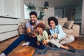 Family sitting on the couch together playing video games, selective focus Royalty Free Stock Photo