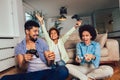 Family sitting on the couch together playing video games, selective focus Royalty Free Stock Photo