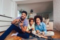 Family sitting on the couch together playing video games, selective focus Royalty Free Stock Photo