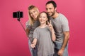 smiling family taking selfie on smartphone while daughter showing peace symbol, isolated Royalty Free Stock Photo