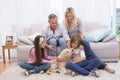 Smiling family with their pet yellow labrador on the rug Royalty Free Stock Photo