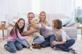 Smiling family with their pet yellow labrador on the rug Royalty Free Stock Photo