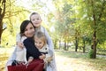 Smiling family together in plaid on autumn picnic