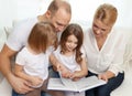 Smiling family and two little girls with book Royalty Free Stock Photo