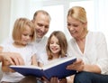 Smiling family and two little girls with book Royalty Free Stock Photo