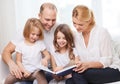 Smiling family and two little girls with book Royalty Free Stock Photo