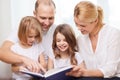 Smiling family and two little girls with book Royalty Free Stock Photo