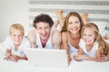 Smiling family using laptop on bed Royalty Free Stock Photo