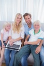 Smiling family using laptop in their living room Royalty Free Stock Photo